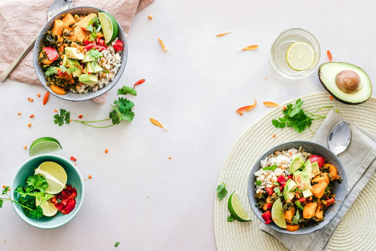 Ciotole vegetariane con riso, verdure, avocado e lime