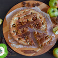 Crostata di mele con farina di carrube, decorata con cannella, mele fresche e baccelli di carruba
