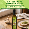 Bottiglia di olio di sesamo Cibo Crudo su tavolo di legno, accanto a fetta di pane con germogli e ciotola di semi