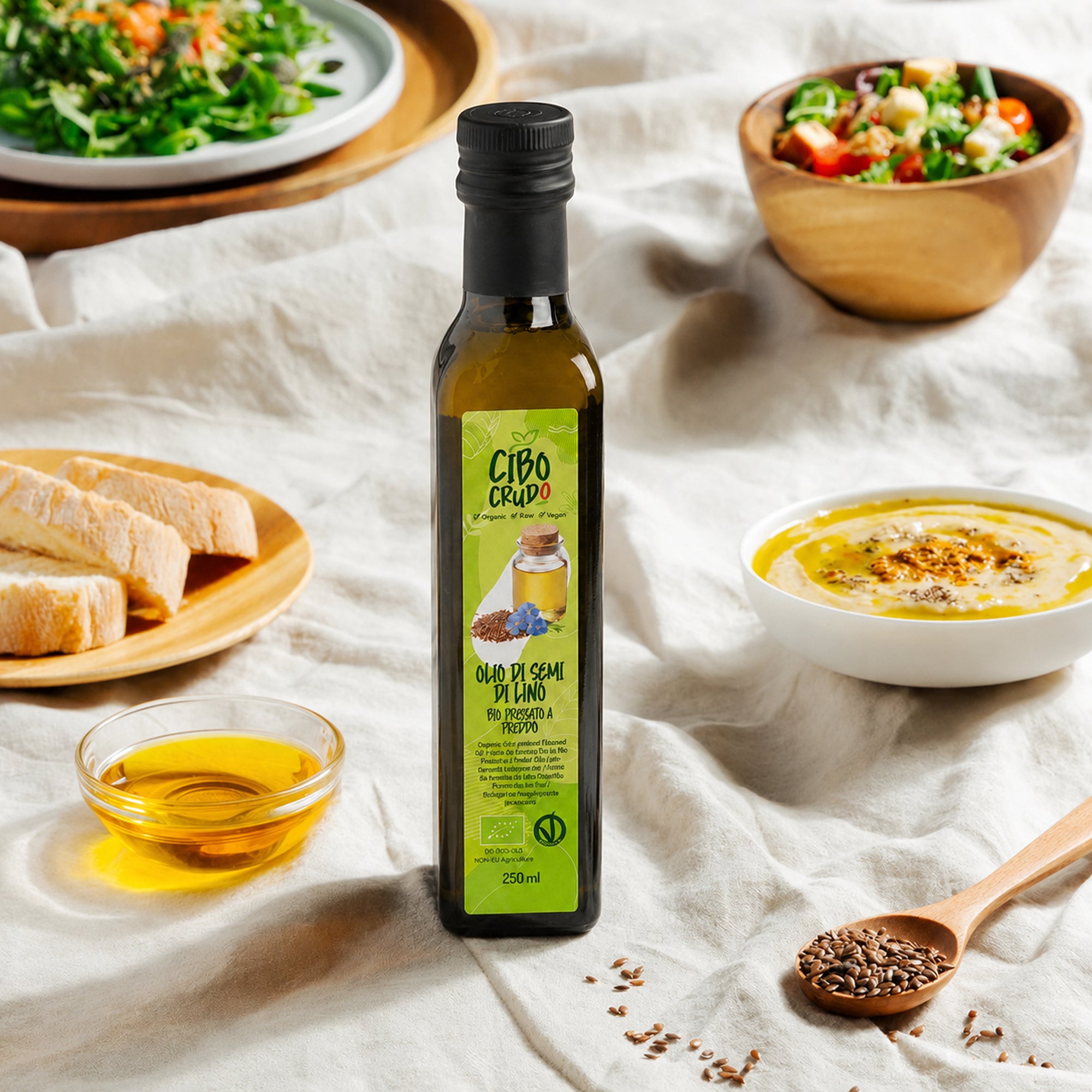 Bottiglia di Olio di semi di lino Cibo Crudo su tavola con insalata, pane, hummus e semi di lino