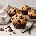 Muffin al cioccolato con bacche di Vaniglia Bourbon e pezzi di cioccolato fondente su superficie chiara